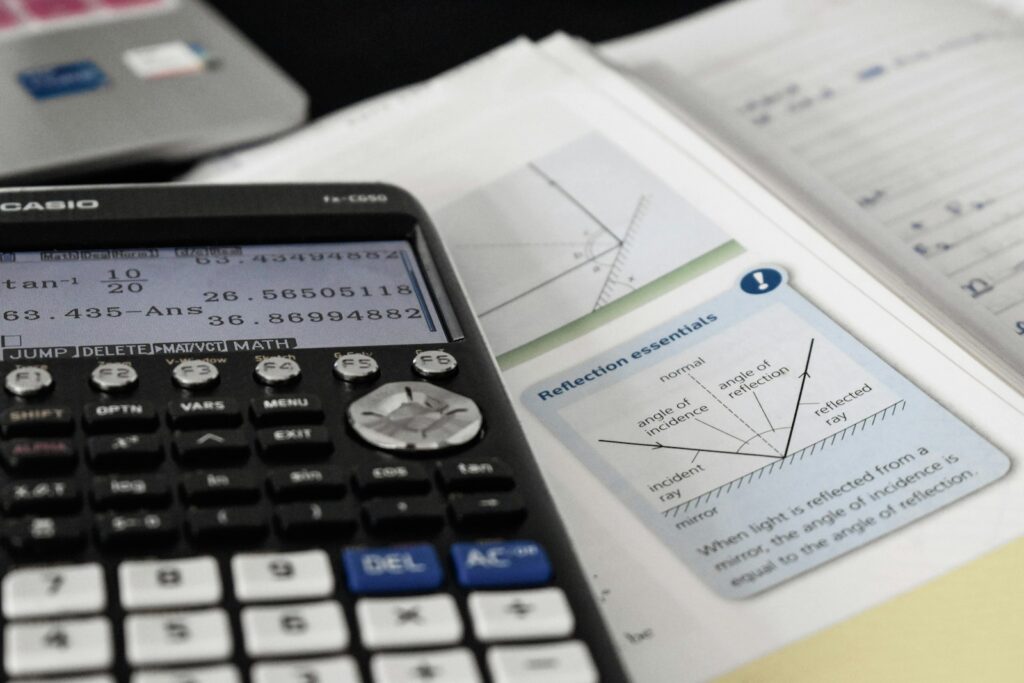 Come integrare gli appunti con il libro 2 Un libro con sopra una calcolatrice da cui prendere gli esercizi necessari per integrarli con gli appunti