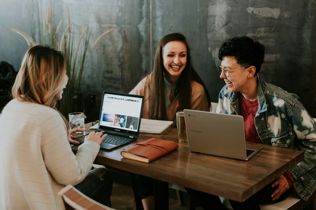 Come scrivere una lettera motivazionale efficace 2 three people sitting in front of table laughing together