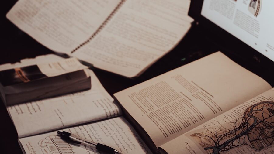 an open book sitting on top of a desk next to a computer